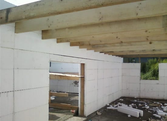 Заводим деевянные балки между этажами во время кладки стены